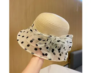 Dettaglio cappello secchiello organza estate, paglia beige con pois neri e fiore.
