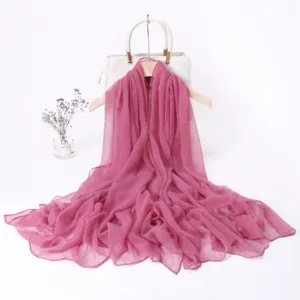 Detail view of a long pink chiffon scarf draped elegantly on hanger for detail display.