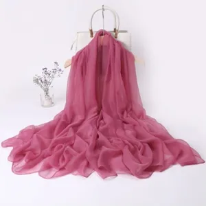 Detail view of the elegant pink chiffon scarf showing soft draped texture and fabric flow.