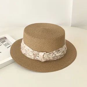 Detailansicht des sommerlichen flachen Damen-Strohhuts mit floralem Chiffonband.