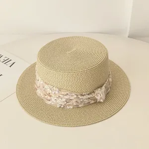 Detailansicht eines flachen Strohhutes für Damen mit elegantem Blumen-Netzband.