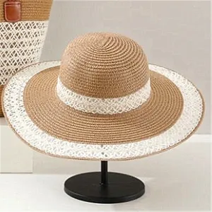 Vista detallada de un sombrero de paja de ala ancha con encaje blanco elegante para el verano.
