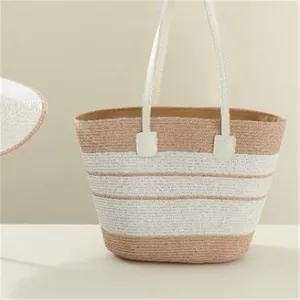 Detailed view of the straw woven handbag with white and brown stripes and elegant leather handles.