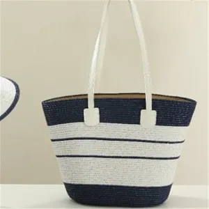 Blue and white striped straw tote bag detailed view, elegant woven texture design for summer.