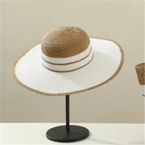 Closeup detail of the stylish summer straw sun hat featuring chic brown and white crown.