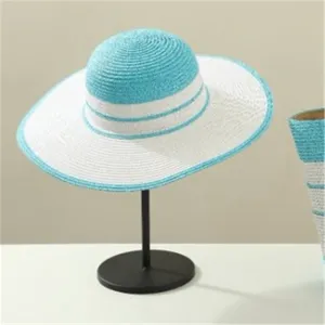Detailed view of the stylish summer straw sun hat with blue and white stripes, elegant wide brim.