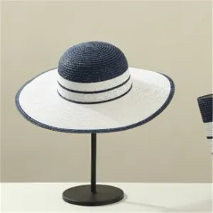 Summer straw sun hat with stylish blue and white stripes wide brim for beach vacation travel.