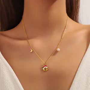 Collier de Noël doré avec bonhomme de neige, lune et perle, bijou festif chic pour femmes.