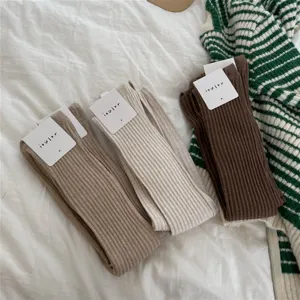 Detailed flat lay view of cozy ribbed knit over-the-knee socks in three autumn colors.