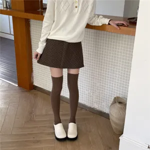Detailed view of ribbed over-the-knee socks worn with a chic outfit, cozy autumn style.