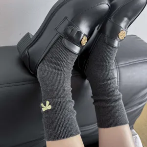Close-up detail of women's ribbed mid-tube socks featuring a cute yellow embroidered bow.