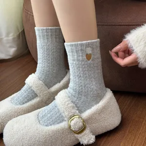 Cozy grey knit crew socks featuring sweet embroidered hearts paired with soft fluffy shoes.