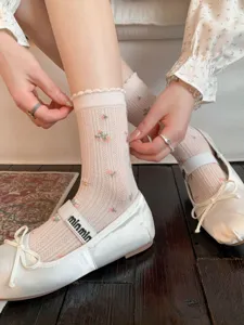 Primo piano di calzini medi floreali in stile giapponese con delicati polsini in pizzo.