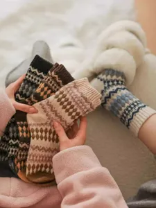 Close-up of cozy vintage Fair Isle patterned wool knit winter slouch socks in warm tones.