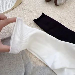 Primer plano detallado de calcetines lisos de algodón con puños elásticos y textura muy suave.