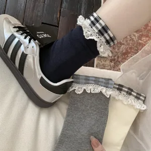 Vue détaillée de chaussettes mi-hautes à carreaux rétro avec bordure en dentelle délicate.
