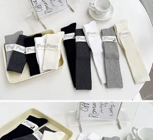 Detailed view of solid color ribbed cotton socks in various neutral shades displayed neatly.