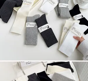 Close-up of ribbed cotton socks in various colors with paper band packaging details.