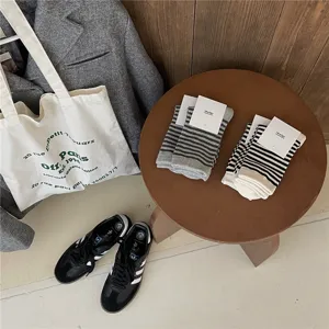 Gedetailleerd overzicht van gezellige gestreepte damessokken op een houten kruk in lifestylescène.