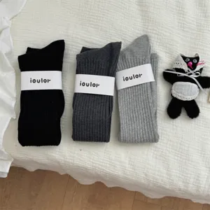Solid color long tube stacking socks with paper band, comfortable knitwear detail view.