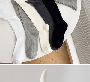 Detail view of ribbed long socks in various colors, soft cotton knit material for autumn and winter.