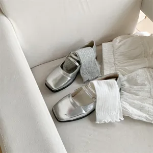 Details showing ballet style mid-calf socks paired with silver Mary Jane shoes and skirt.