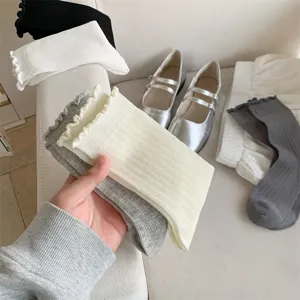 Detail shot of casual white and grey ruffled crew socks, cotton lightweight summer knit.