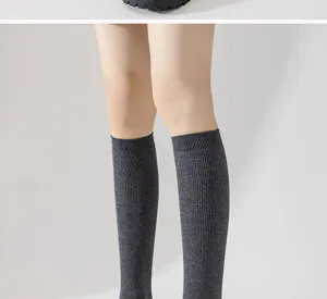 Detail shot of dark grey ribbed knee high socks, soft cotton knit fabric, classic casual style.