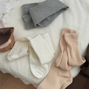 Cozy ribbed long socks detail shot, soft knit fabric in neutral colors for autumn winter cozy style.