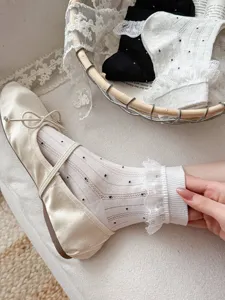Close-up detail view of sweet lace polka dot mid-calf socks paired with elegant cream flat shoes.