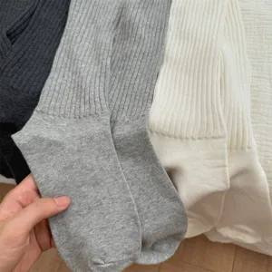 Close-up of soft ribbed knit slouch socks, showing fine texture and comfortable fabric stretch.