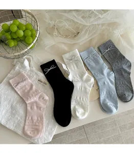 Close-up detail of sweet mesh mid-tube socks featuring cute bow accents in multiple colors.