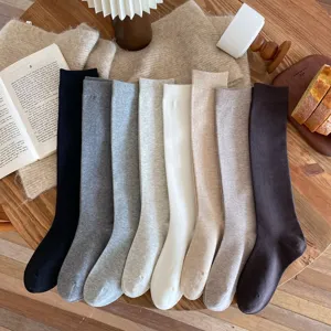 Knitted high tube socks detail shot, solid color cozy winter long stockings for women.