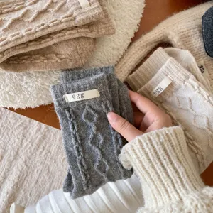 Nahaufnahme von gemütlichen Wollstrick-Socken mit Stofflabel und weicher, warmer Textur.