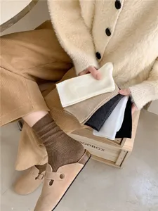 Close-up of women's ribbed slouch socks in versatile autumn winter neutral tones.