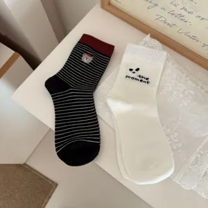 Vue détaillée de chaussettes mi-hautes en coton rayées et brodées mignonnes pour femmes.