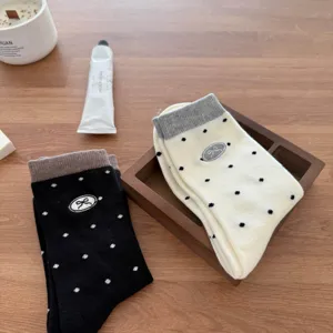 Cute women mid-tube socks featuring classic polka dots and sweet embroidered bow design.