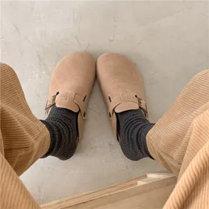 Close-up detail of cozy autumn ribbed mid-tube socks paired with casual suede clogs.