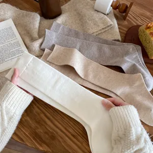 Women solid color long socks detail, cozy cotton high socks for daily wear and warm autumn outfits.