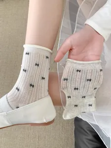 Close-up detail of women's summer sheer mesh crew socks featuring cute black bow patterns.