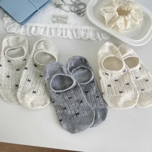 Nahaufnahme von atmungsaktiven Mesh-Füßlingen mit niedlichen kleinen Schleifenmustern.