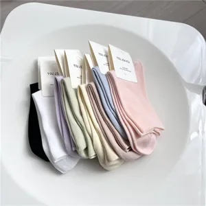 Detailed shot of multi-color cotton mid-calf socks neatly arranged with paper tags on display.