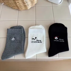 Gros plan détaillé de chaussettes mignonnes brodées, texture en tissu de coton doux.