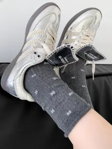 Metallic sneakers paired with cute bow pattern grey cotton stack socks for trendy daily wear.