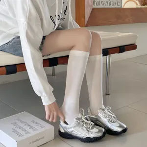 Women knee high socks casual solid color long stockings paired with silver fashion sneakers.