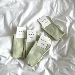Comfortable cotton mid-calf women's socks in light green with hanging tags for daily wear.