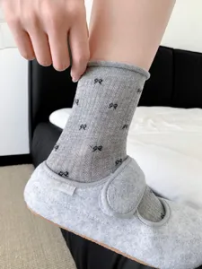 Korean style grey crew socks with cute black bow prints and delicate cuff detail for women.