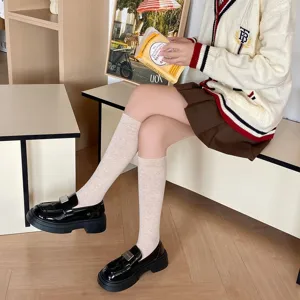Knee high solid color socks for women, paired with preppy style loafers and skirts for autumn winter.