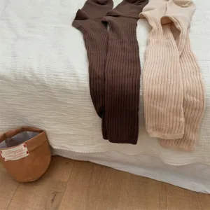 Detailed shot of cozy knit long stockings in brown and beige, soft winter ribbed socks.