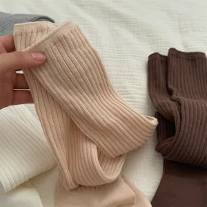 Ribbed knit long stacking socks detail close-up, showing soft winter warm sock texture.